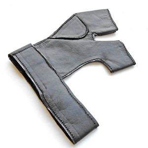 May include: Black leather fingerless glove with a wrist strap. The glove has a cut-out for the index finger and thumb.