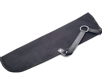 Puede incluir: Un carcaj de lona negro con una correa de cuero y un anillo de metal. El carcaj está diseñado para contener flechas.