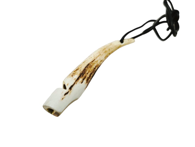May include: A white antler whistle with a brown pattern, attached to a black cord. The whistle is about 5 inches long.