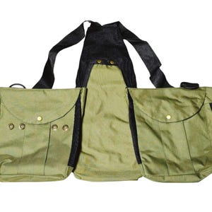 May include: A green canvas hunting vest with multiple pockets and adjustable straps. The vest has a black mesh back panel and is designed for carrying hunting gear.