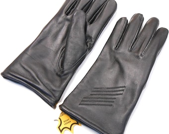 May include: A pair of black leather gloves with a stitched design on the back of one glove. The gloves have a fold-over cuff and a label that reads "Echt Leder".