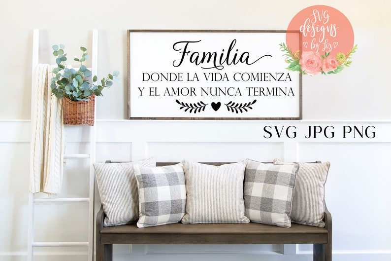 May include: A black and white sign with the Spanish text "Familia Donde La Vida Comienza Y El Amor Nunca Termina" which translates to "Family Where Life Begins And Love Never Ends". The sign is hanging on a white wall above a wooden bench with three pillows.