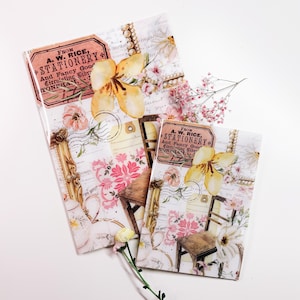 Può includere: Due quaderni di cancelleria decorativi con un design a collage. Il design include motivi floreali, francobolli vintage e il testo "FROM A. W. RICE, STATIONERY And Fancy Good Circulating Librr TONFHAM,". I quaderni presentano fiori gialli e rosa.