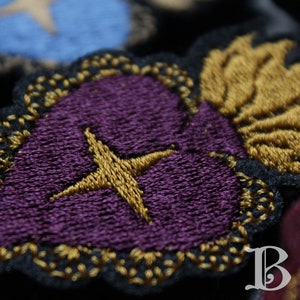 Broche brodée Cœur Ardent étoilé violet fond noir