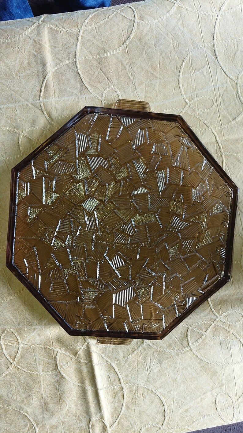 May include: Octagonal glass serving tray with a brown, textured, geometric pattern. The tray has two handles on the sides.