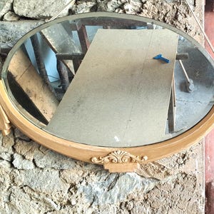 Art Nouveau carved wooden mirror, France, 1920. Decorative object for bedroom. Oval frame in patinated gold-colored wood. Second-hand item.