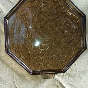 May include: Octagonal brown glass serving tray with a geometric pattern. The tray has a raised edge and two handles.