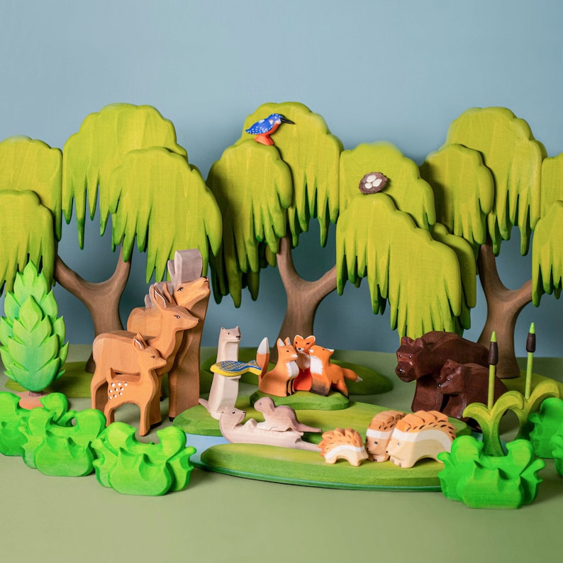 Wooden forest scene with a variety of animals including foxes, hedgehogs, and birds, set amongst green trees on a green base.
