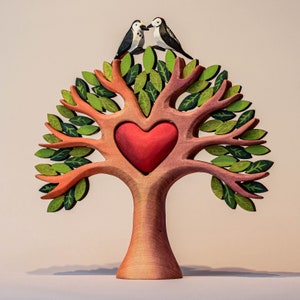 Wooden heart tree toy featuring a central red heart with two bird figurines touching beaks at the top of the tree