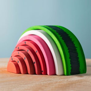 Montessori oak watermelon stacker toy disassembled, with each slice showing seed patterns.