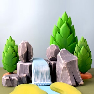 Artisan-crafted wooden mountain and waterfall playset with green island accents, ideal for creative storytelling and geography lessons.