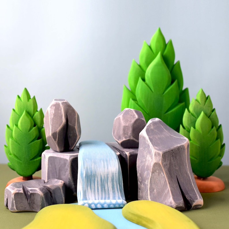 Artisan-crafted wooden mountain and waterfall playset with green island accents, ideal for creative storytelling and geography lessons.