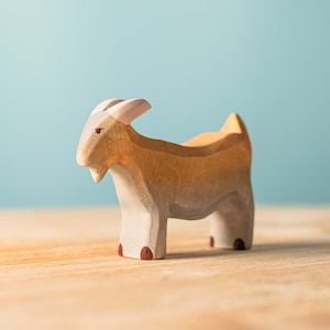 Artisanal wooden goat toy standing in profile, handcrafted with two-tone body for Montessori play.