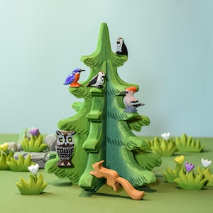 a small wooden tree with birds and flowers