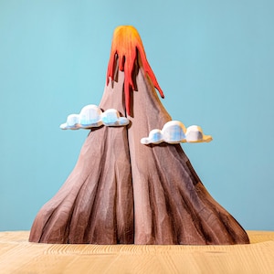 Educational wooden toy depicting a volcanic eruption, with fiery lava accents and peaceful clouds, designed to spark imaginative play.