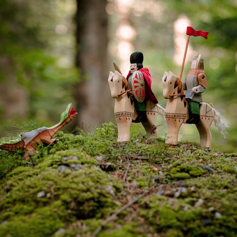 A scene of wooden toy knights in a forest setting, with one knight holding a red flag high, evoking a storybook atmosphere with natural surroundings.