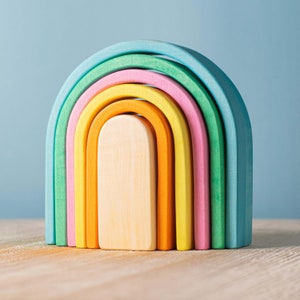 Handmade oak wooden puzzle in a rainbow of colors, part of the ARCADE collection designed to encourage cognitive development in children.