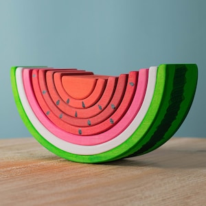 Side view of a wooden watermelon stacker toy, showcasing layered design and natural oak material.
