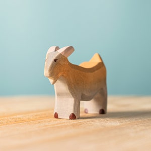 Side view of handmade wooden goat figure, Montessori educational toy with natural wood grains.