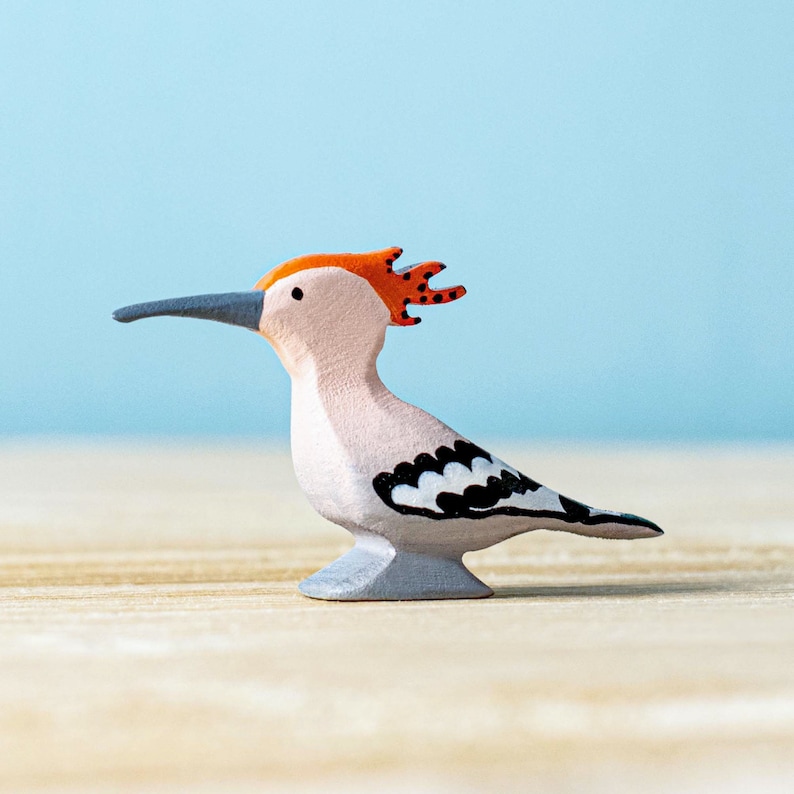 a small bird figurine on a wood surface