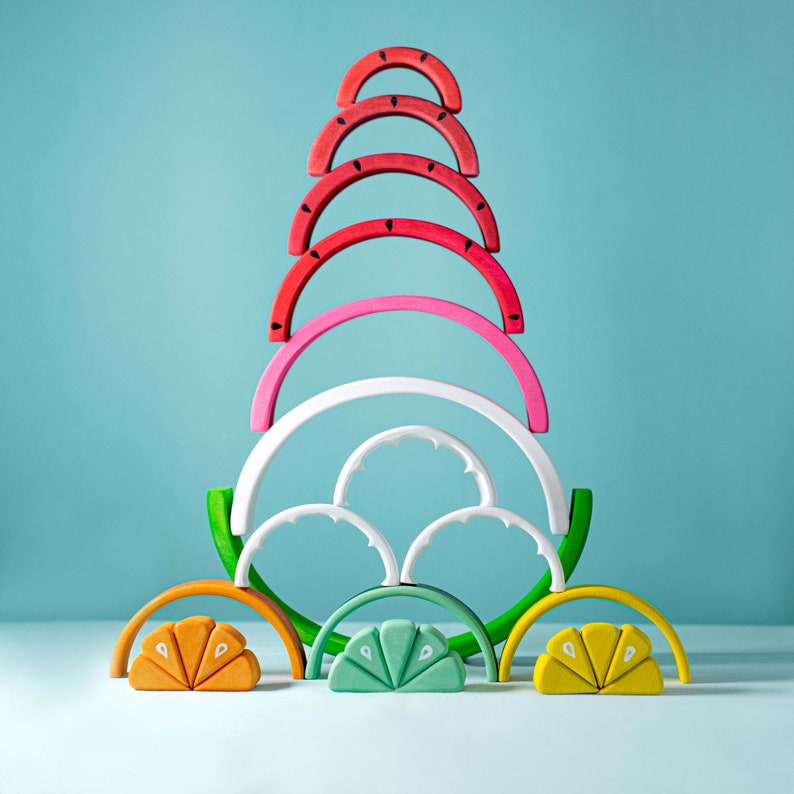Stacked watermelon wooden toy with colorful arches mimicking fruit slices, designed for Montessori play.