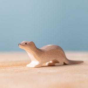 Solo wooden otter figurine with a smooth finish and detailed facial features captured in profile, emphasizing its playful character.