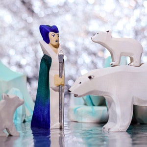 A wooden figurine standing among ice-like wooden blocks with a glittery background.