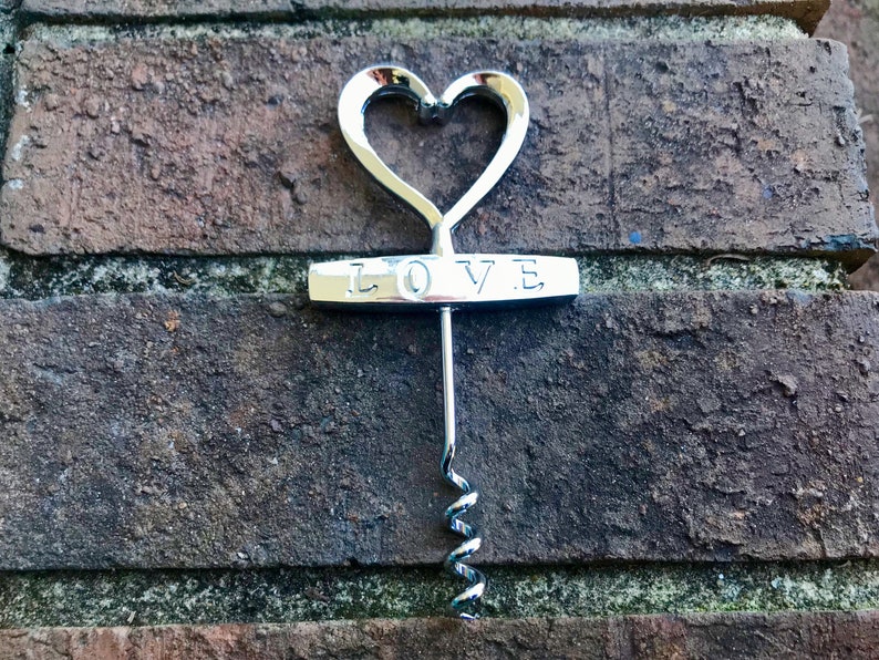 May include: Silver heart-shaped corkscrew with the word "LOVE" engraved on the handle.