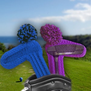 Puede incluir: Dos fundas para la cabeza de palo de golf de punto con pompones. Una es azul con un pompón negro y la otra es morada con un pompón morado.
