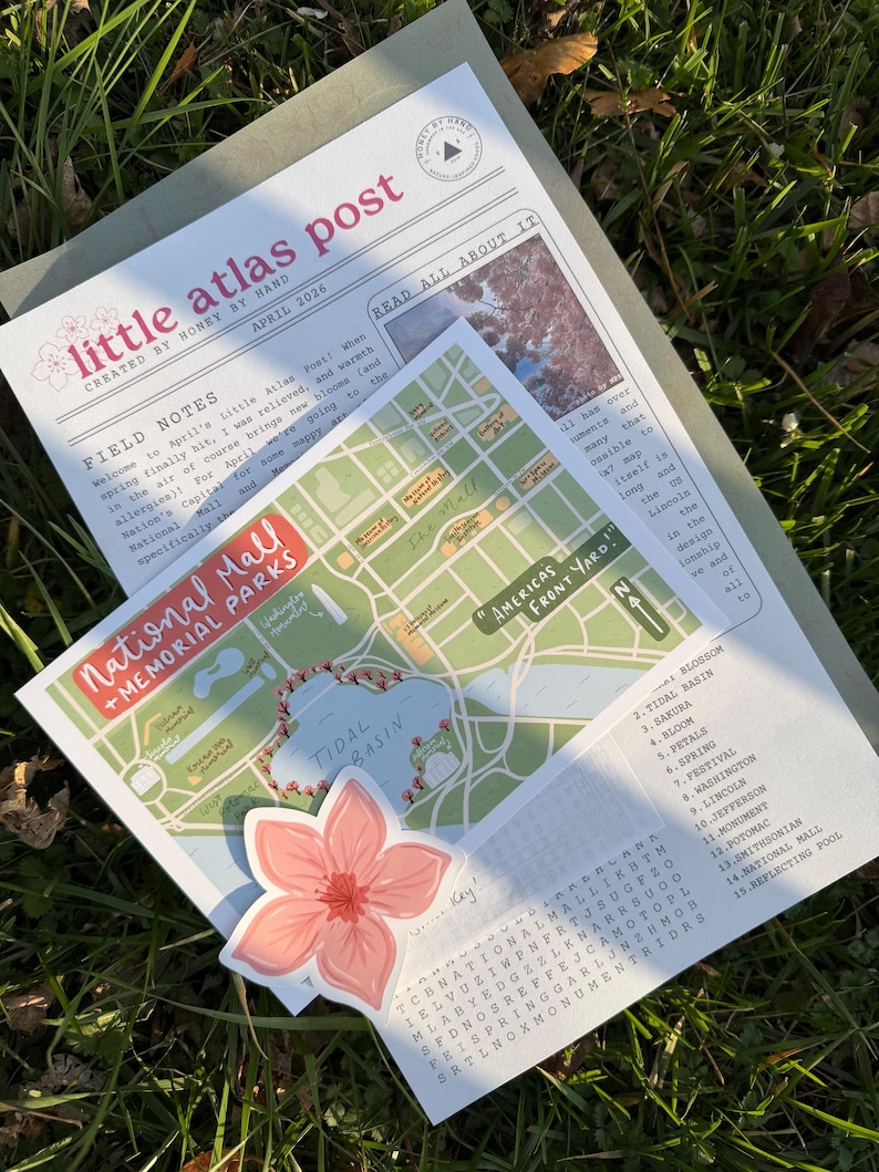 May include: A collection of paper ephemera, including a map of the National Mall, a newspaper-style newsletter, and a floral sticker. The map highlights Tidal Basin and surrounding memorials. The newsletter is titled "little atlas post."