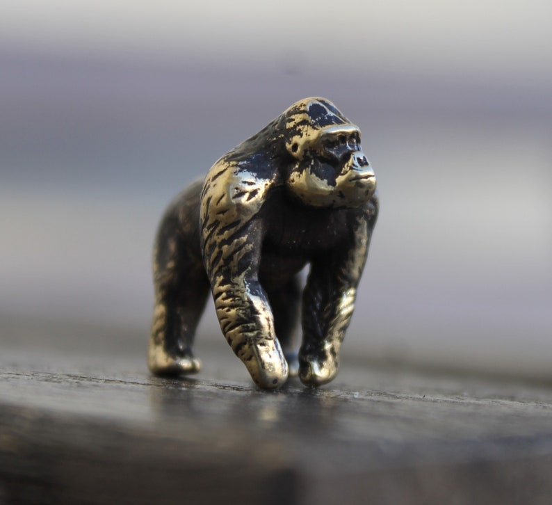 K&ouml;nnte beinhalten: Eine kleine, detaillierte Bronzeskulptur eines Gorillas. Der Gorilla steht auf allen Vieren und hat ein realistisches Aussehen.