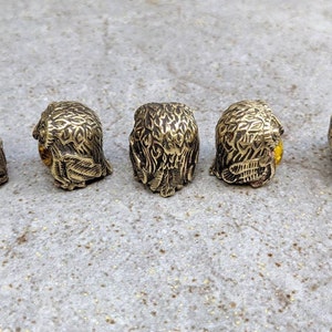 May include: Five small brass owl figurines with amber glass eyes. The owls are facing different directions.
