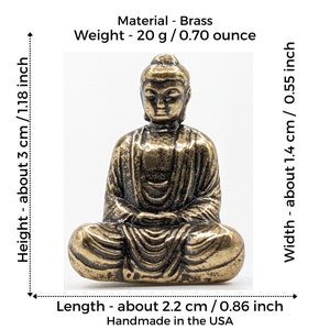 May include: A small, gold-colored brass Buddha statue sitting in a meditative pose. The statue is about 3 inches tall and weighs 0.70 ounces.