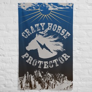 Könnte beinhalten: Blaue Wandfahne mit dem Text "CRAZY HORSE PROTECTOR" in einer verwitterten Schriftart. Die Fahne zeigt eine weiße Pferdekopf-Silhouette mit einem Blitz, einer Sonne und Bergmotiven.