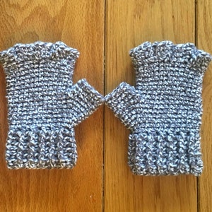 May include: A pair of grey and white fingerless gloves with a ribbed cuff.