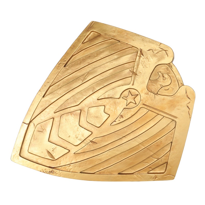 May include: A gold-colored shield with a star in the center and a decorative pattern. The shield has a worn, textured surface.