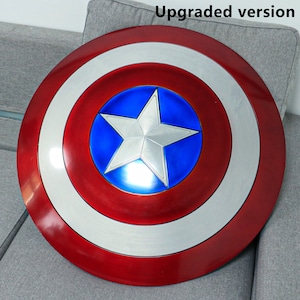 May include: A red, white, and blue Captain America shield with a five-pointed star in the center. The shield is made of metal and has a shiny finish.