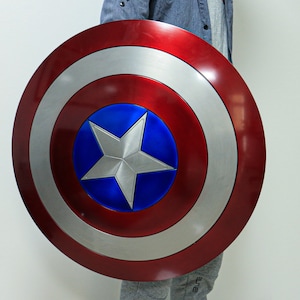 May include: A red, white, and blue Captain America shield with a silver star in the center. The shield is made of metal and has a shiny finish.