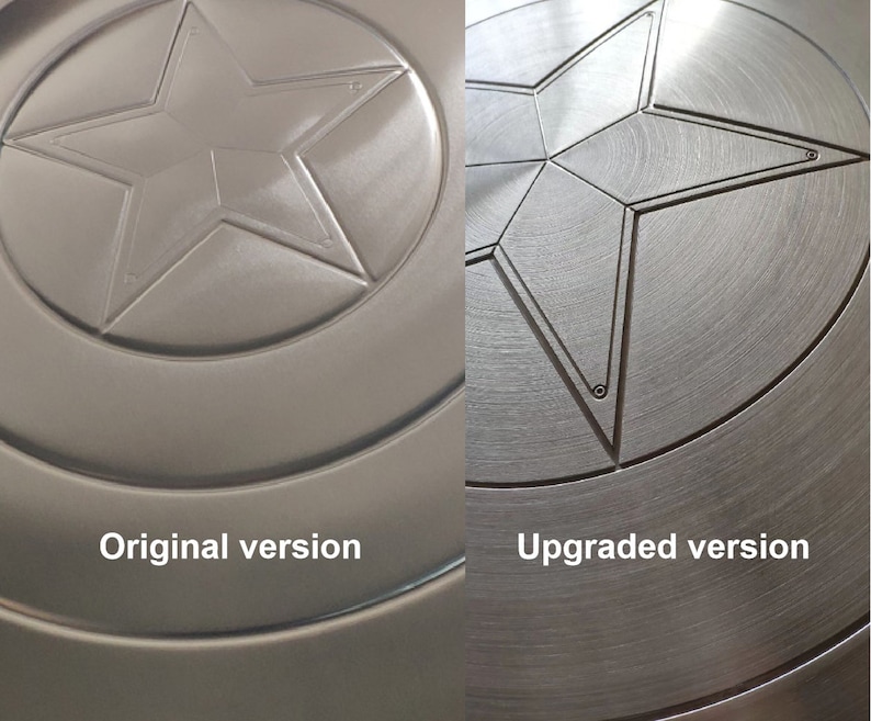 May include: Two versions of a metal Captain America shield. The original version has a smooth, untextured surface. The upgraded version has a brushed metal finish. Both shields feature a five-pointed star in the center.
