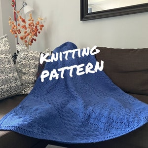 May include: A blue knitted blanket with a textured pattern, resting on a brown couch. The text "Knitting Pattern" is written in white on the blanket.