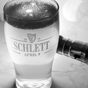 May include: A glass of beer with a white head and a logo that says "Schlett" with the date "April 9" and the years "20" and "19" on either side of the logo.