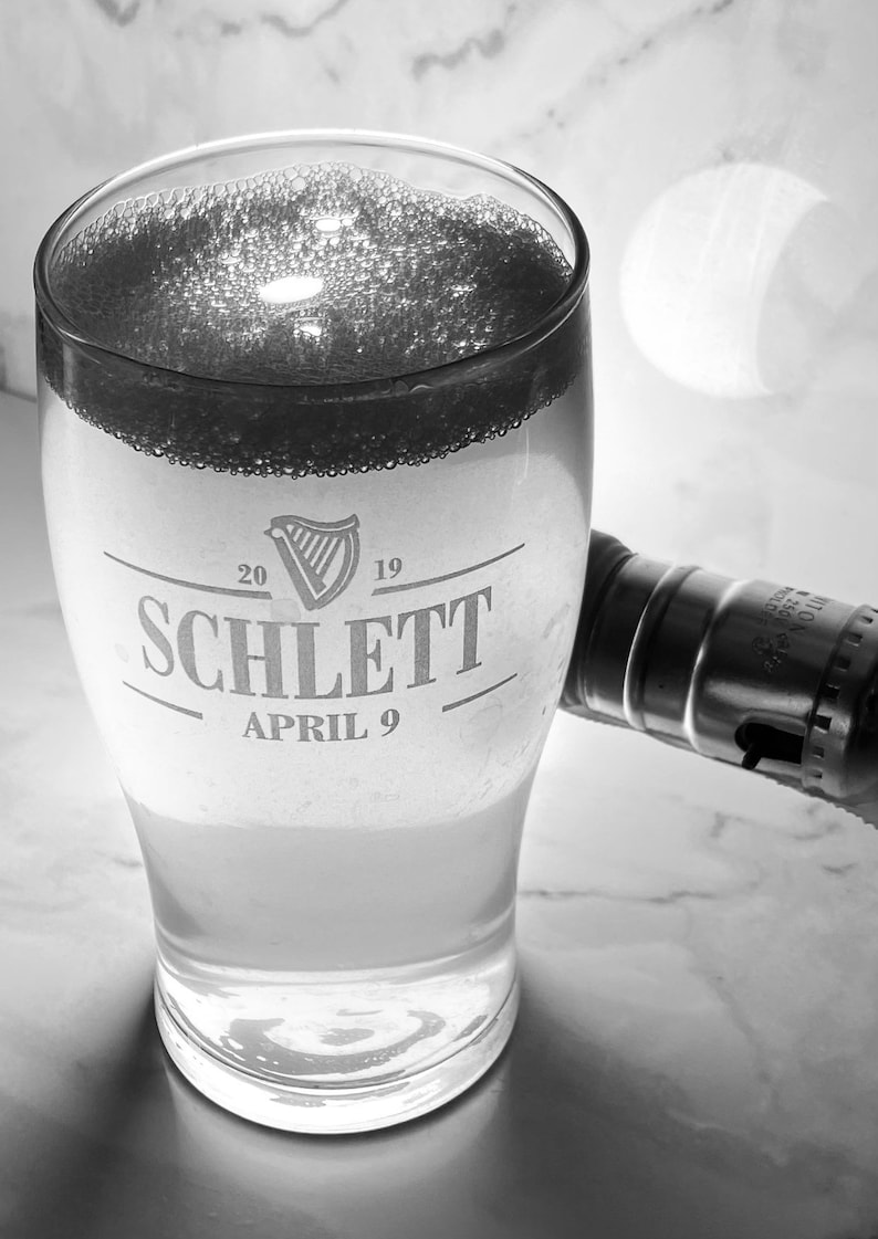 May include: A glass of beer with a white head and a logo that says "Schlett" with the date "April 9" and the years "20" and "19" on either side of the logo.