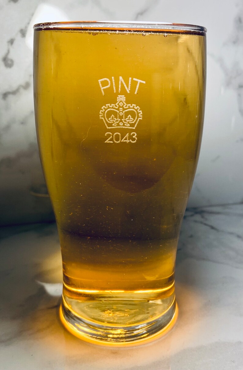 May include: A clear glass pint glass with the words "PINT 2043" etched on the side. A crown is etched above the text.
