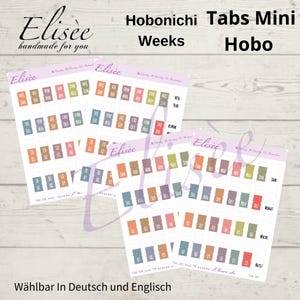 Peut inclure: Quatre feuilles d'onglets de planificateur avec le texte "Hobonichi Tabs Mini Weeks Hobo" et le nom de la marque "Elisee". Les onglets sont de différentes couleurs, dont le bleu, l'orange et le vert, avec des mois et des numéros imprimés. Le texte "Wählbar In Deutsch und Englisch" est également visible.