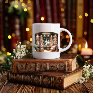 Peut inclure: Une tasse en céramique blanche avec une illustration colorée d'une librairie avec le texte "BOOKSHOP" au-dessus de l'entrée. La tasse est posée sur une pile de vieux livres.