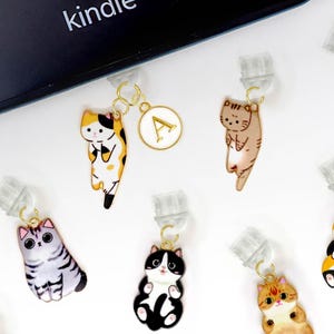 Peut inclure: Une collection de 16 marque-pages en forme de chat colorés. Les clips sont en métal et ont un mécanisme à ressort pour maintenir les pages en place. Les chats sont dans différentes poses et ont des motifs et des couleurs différents, notamment noir, blanc, gris, orange, rose et marron.