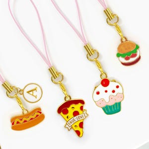 Adornos de comida kawaii para teléfono con diseños de pizza, cupcakes, hamburguesas y donas esmaltadas. Correa rosa con monograma.