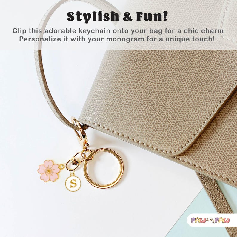 Pink enamel Sakura cherry blossom keychain with gold outline, attached to a gold keyring and an initial charm