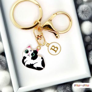 Lindo llavero de gato esmaltado con lunares blancos y negros y monograma personalizado. Divertido llavero kawaii bañado en oro - K-A005-3