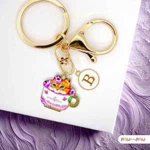 Llavero esmaltado con diseño de gato atigrado pelirrojo en forma de taza de té con flores moradas y monograma personalizado, chapado en oro - K-A006-10